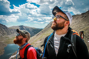 Two friends hiking while using Noz Sunscreen on their nose