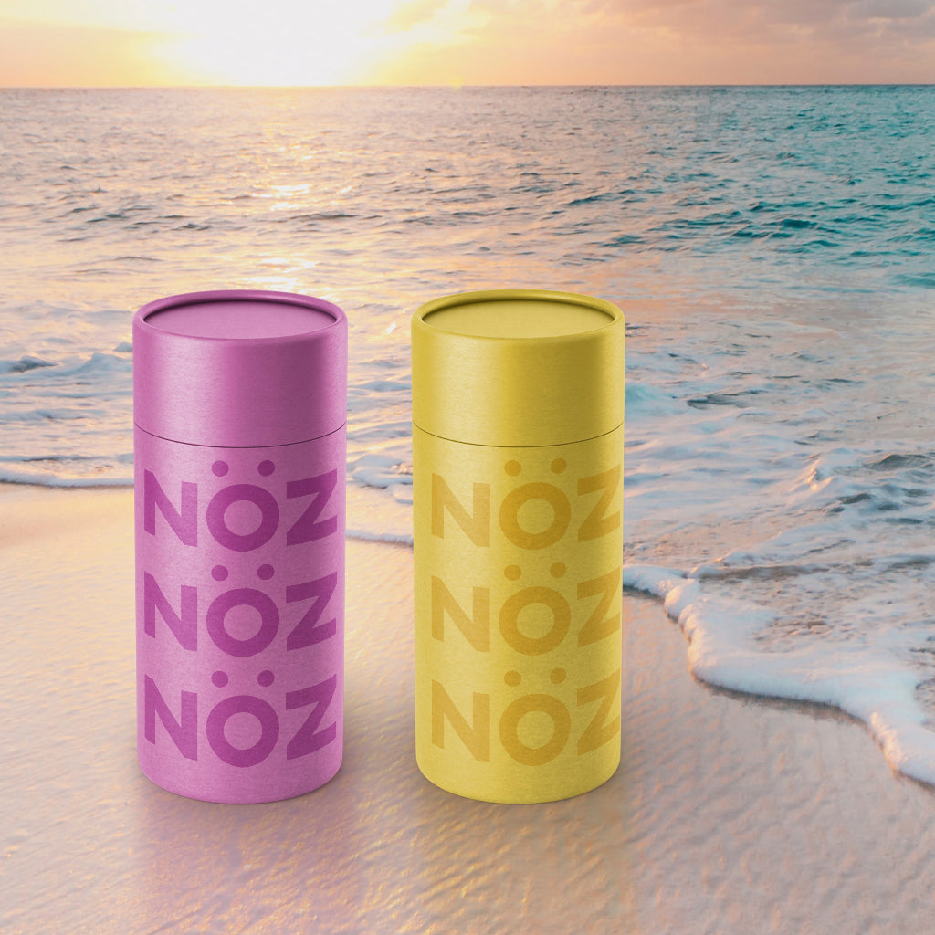 Purple and Yellow Noz sunscreen projected on a beach